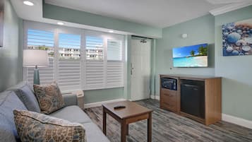 Una sala de estar con sofá, mesa de centro, televisor y microondas.