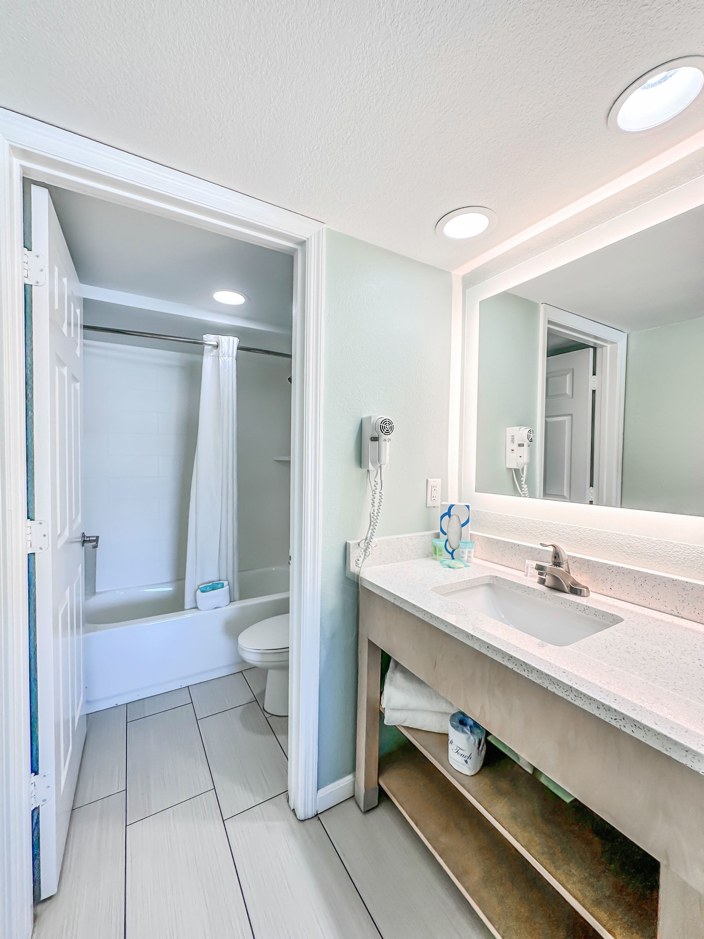 A bathroom with a shower, toilet, and sink.