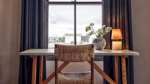 A room with a window, a table, a chair, a vase with flowers, and a lamp. - Maison Twenty Seven (Santa Monica)
