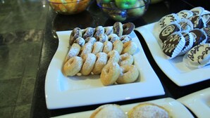 Monipuolinen buffet, jossa on tarjolla erilaisia jälkiruokia ja hedelmiä.