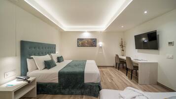 A modern hotel room with a bed, desk, and TV.