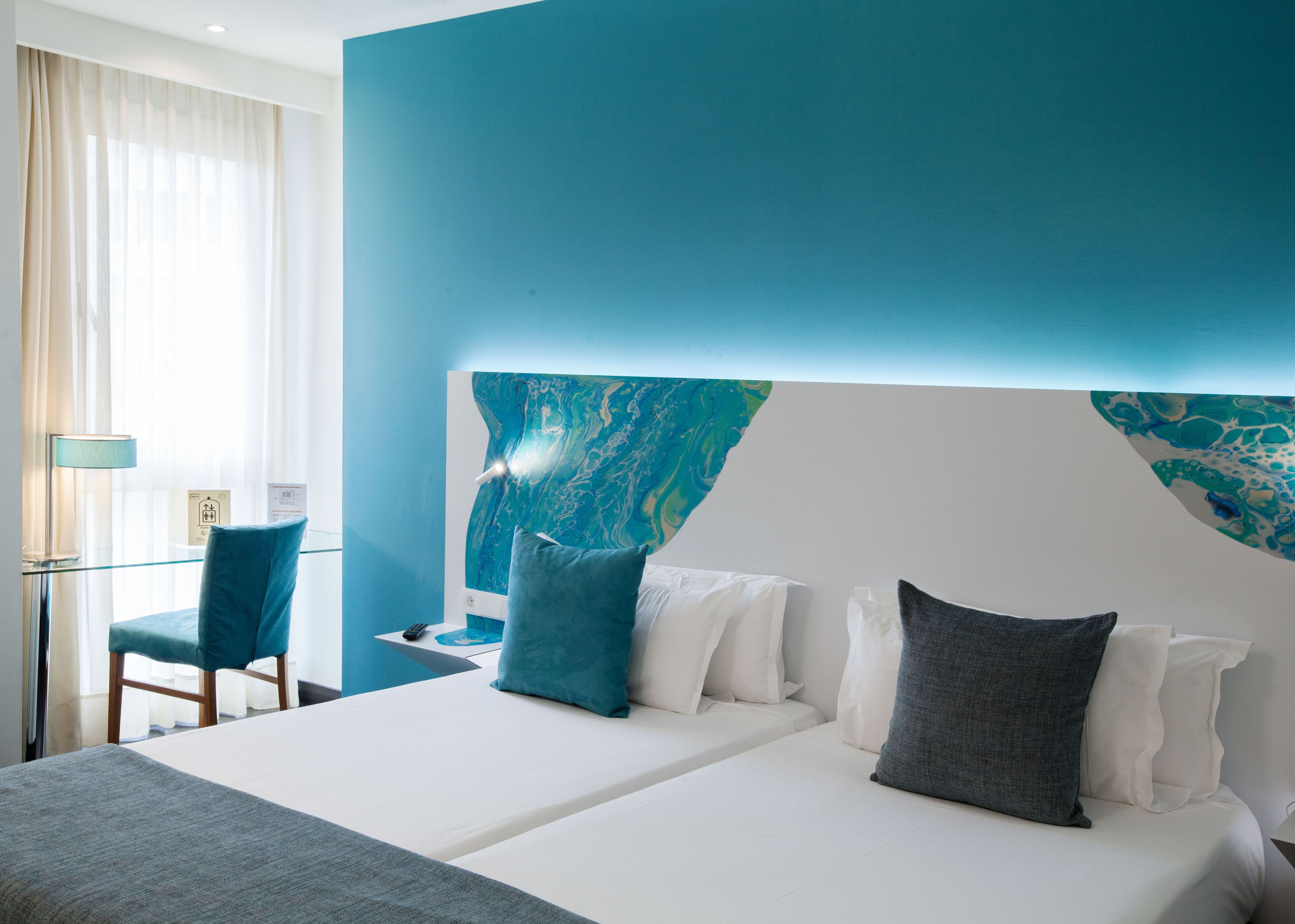 Ein Hotelzimmer mit einem großen Bett, einem Schreibtisch und einem Stuhl.