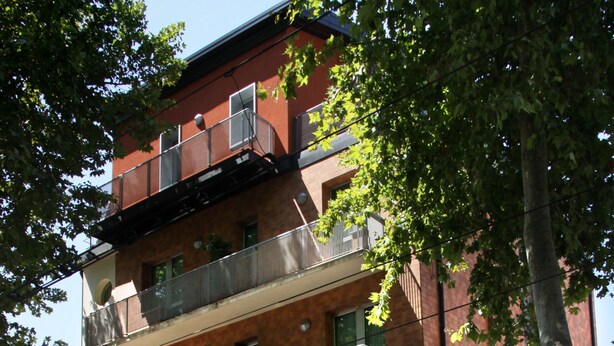 Un hôtel à plusieurs étages, doté de balcons, d’une enseigne indiquant « HÔTEL REGIT » et de drapeaux.