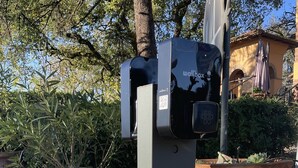 A wallbox with a QR code and a keypad, located outdoors near a brick wall and large planters. - Hotel Villa Ambrosina (Impruneta)