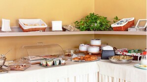 A buffet setup with various food items and containers, including baskets, bowls, and a coffee station. - Hotel Villa Ambrosina (Impruneta)