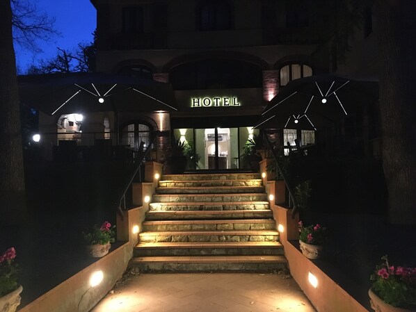 A hotel entrance with a sign, stone steps, and potted plants. - Hotel Villa Ambrosina (Impruneta)