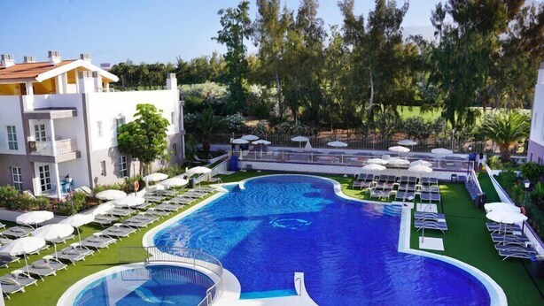 A swimming pool with sun loungers and a small circular pool, surrounded by a well-maintained lawn and trees. - Coral Compostela Beach Golf (Arona)