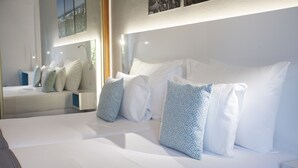 A modern hotel room with a large bed, multiple pillows, and a nightstand. - Coral Compostela Beach Golf (Arona)