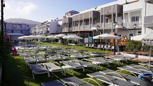 A hotel courtyard with sun loungers, umbrellas, and a pool area. - Coral Compostela Beach Golf (Arona)