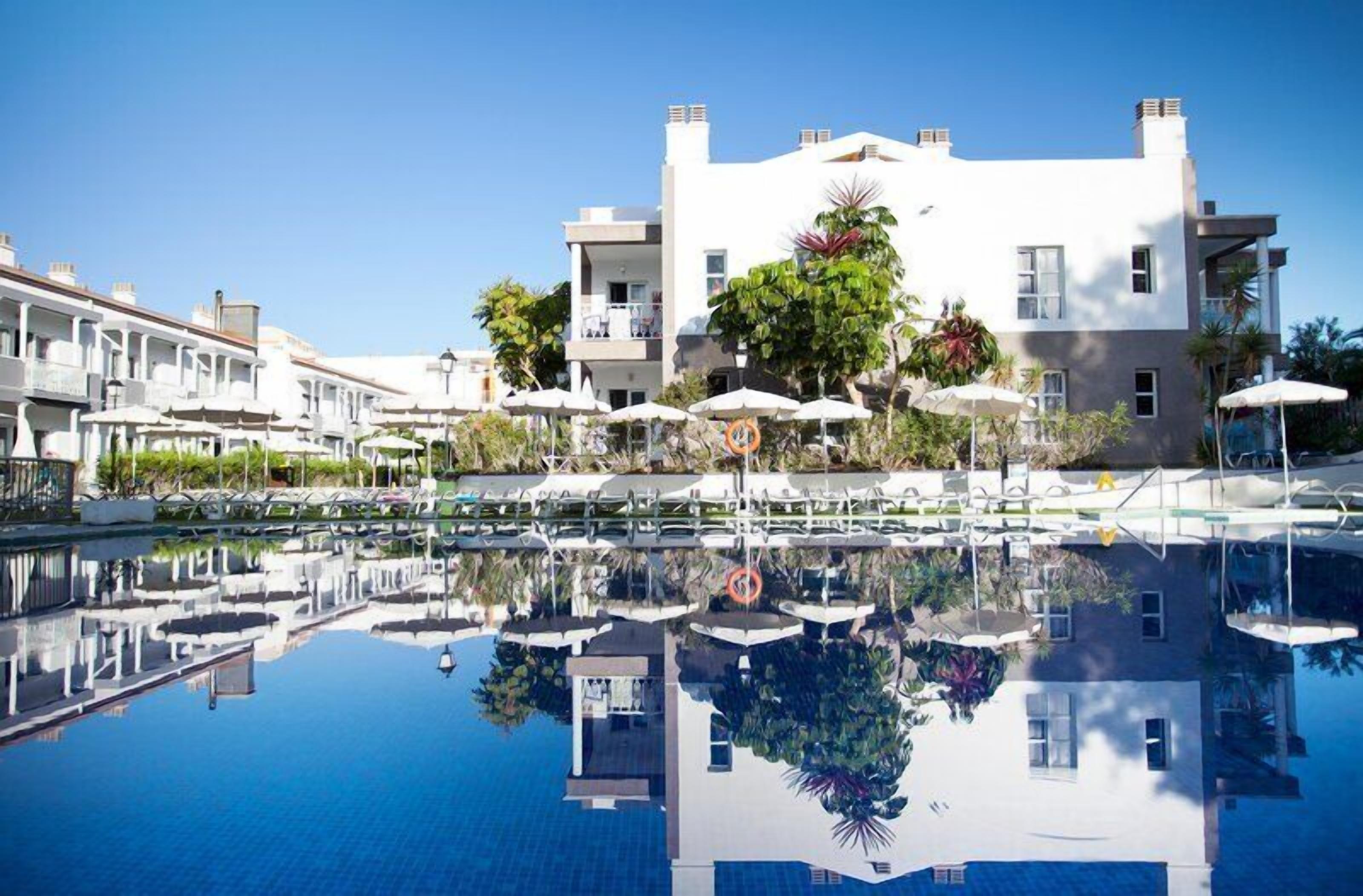 Una piscina al aire libre, tumbonas