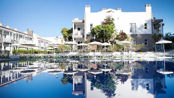 Una piscina al aire libre, sillones reclinables de piscina