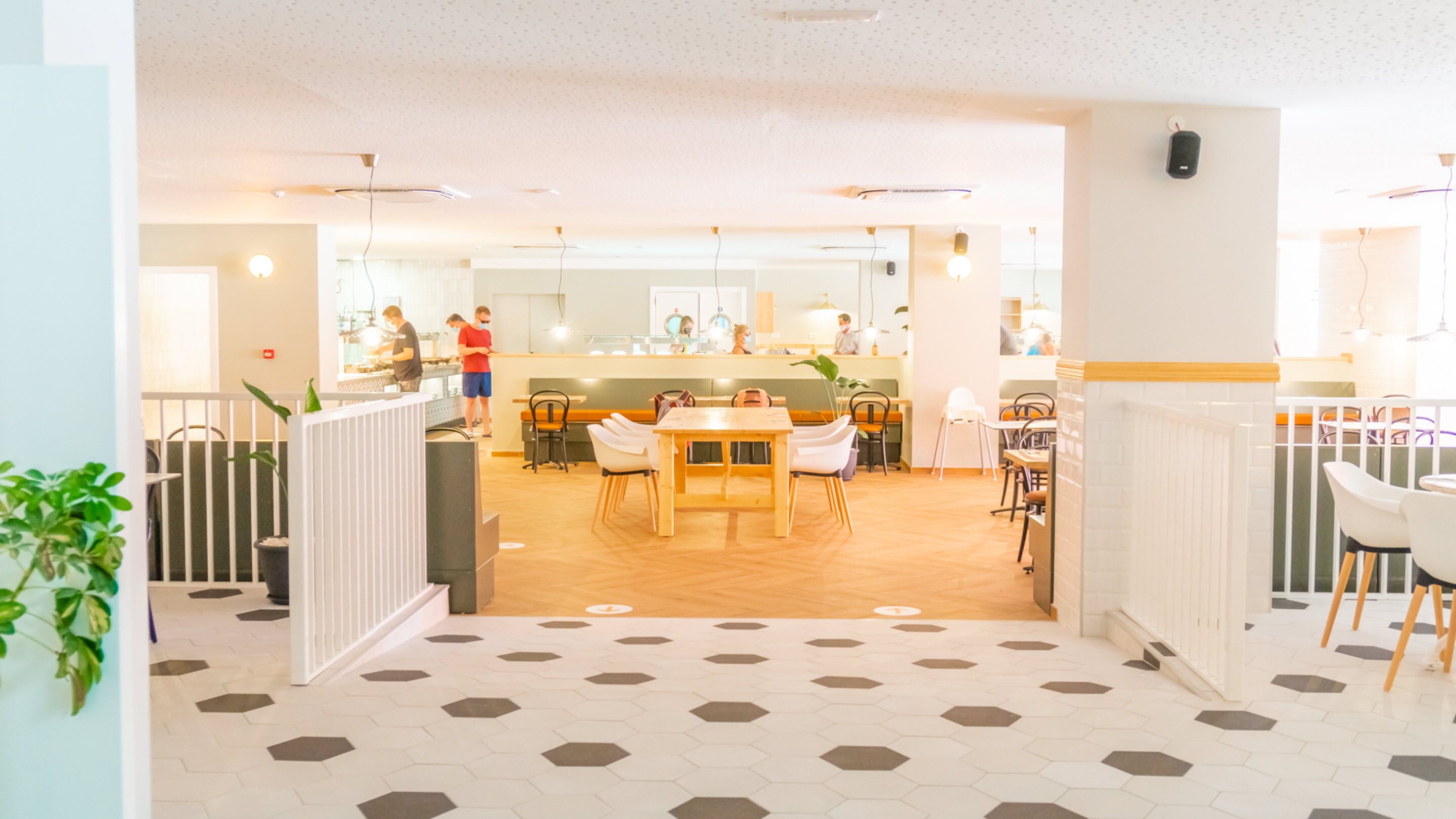 Een modern interieur met een centrale eethoek, een keuken en een receptiebalie.