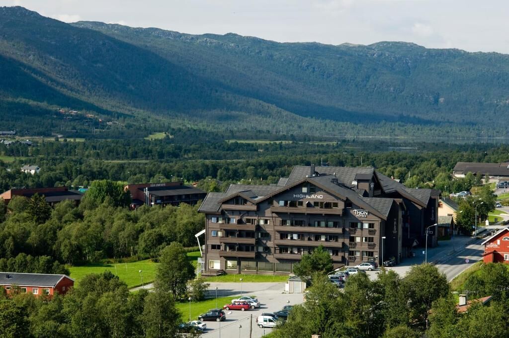 Un hôtel à plusieurs étages, doté d’un design moderne, situé dans une région montagneuse, entouré d’une végétation luxuriante et offrant une vue dégagée sur le paysage environnant.