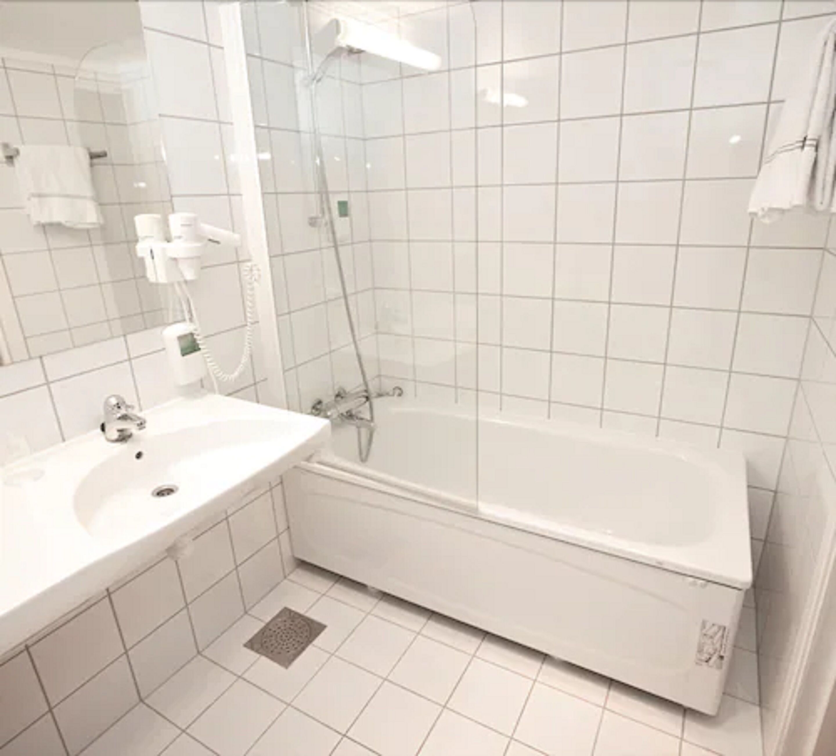 A bathroom with a white sink, a bathtub, and a shower.