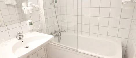 A bathroom with a white sink, a bathtub, and a shower.