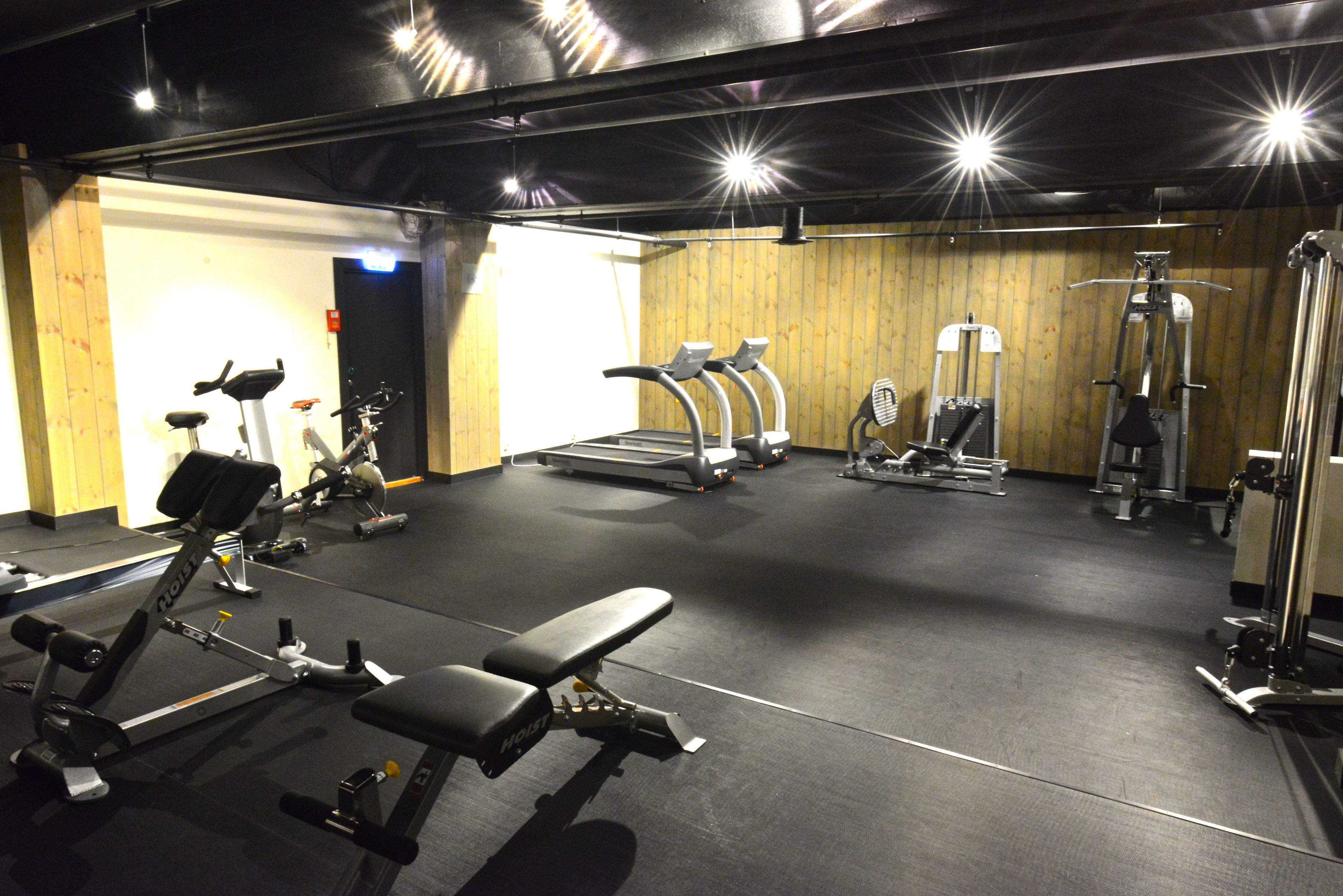 A gym with treadmills, elliptical machines, and weightlifting equipment.
