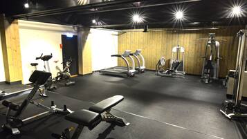 A gym with treadmills, elliptical machines, and weightlifting equipment.