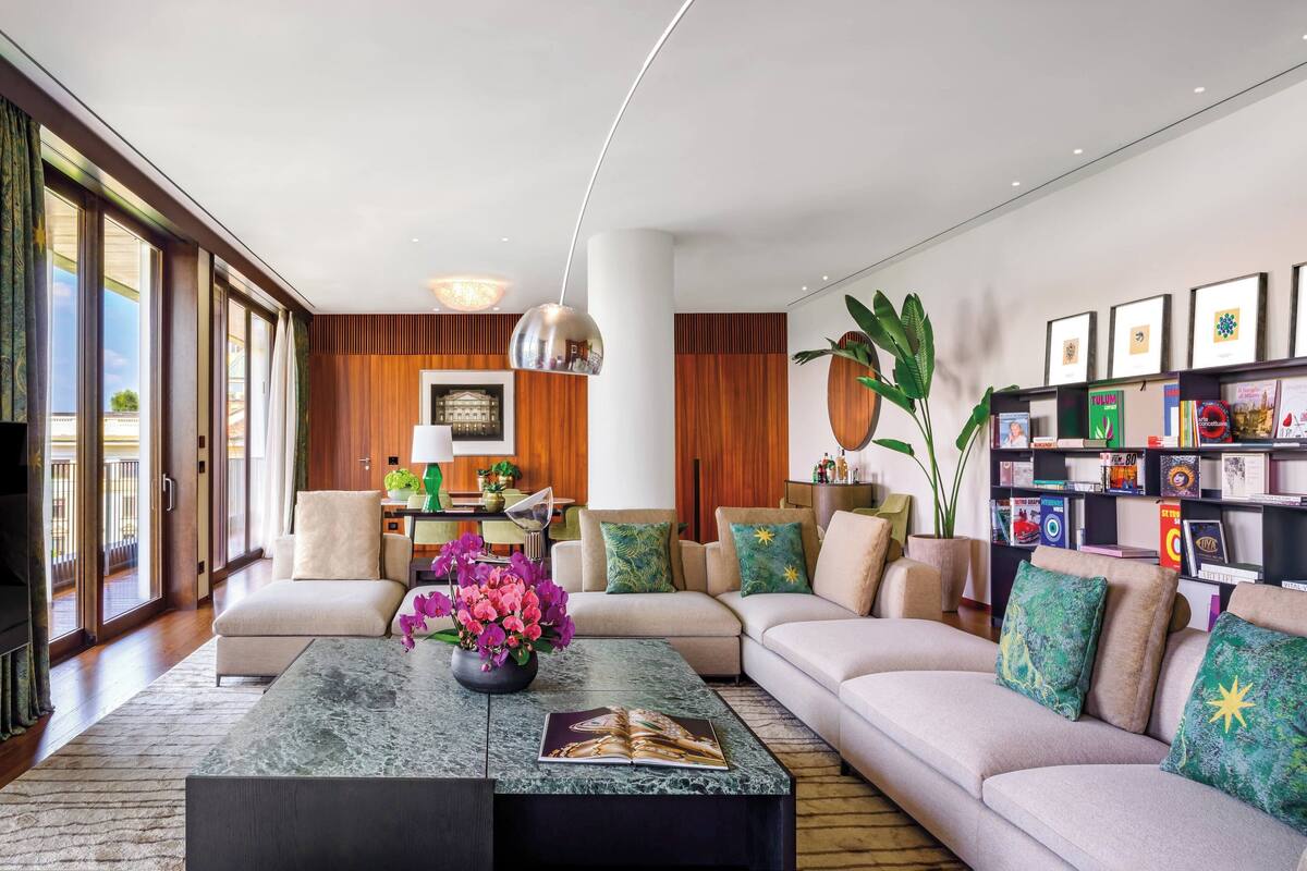 A modern living room with a sofa, coffee table, and bookshelf.