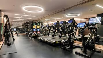 A gym with treadmills, weight machines, and exercise balls.