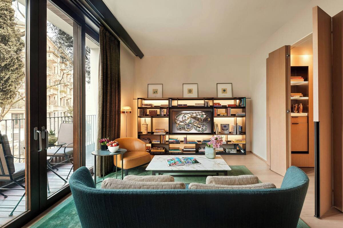A modern living room with a sofa, coffee table, and bookshelves.
