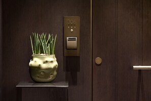 A modern elevator with a digital display showing the number 306, a potted plant, and a metallic door handle. - Bvlgari Hotel Milano (Milan)