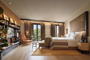 A modern bedroom with a large bed, a bookshelf, a seating area, and a view of the outdoors. - Bvlgari Hotel Milano (Milan)
