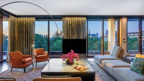Un salon moderne comprenant un canapé, des fauteuils, une table basse et un téléviseur.