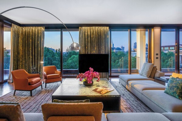A modern living room with a sofa, armchairs, a coffee table, and a TV. - Bvlgari Hotel Milano (Milan)
