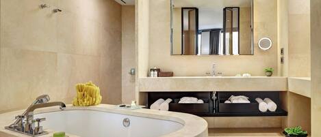 A modern bathroom with a freestanding bathtub, a large mirror, and a vanity with shelves for towels and toiletries.