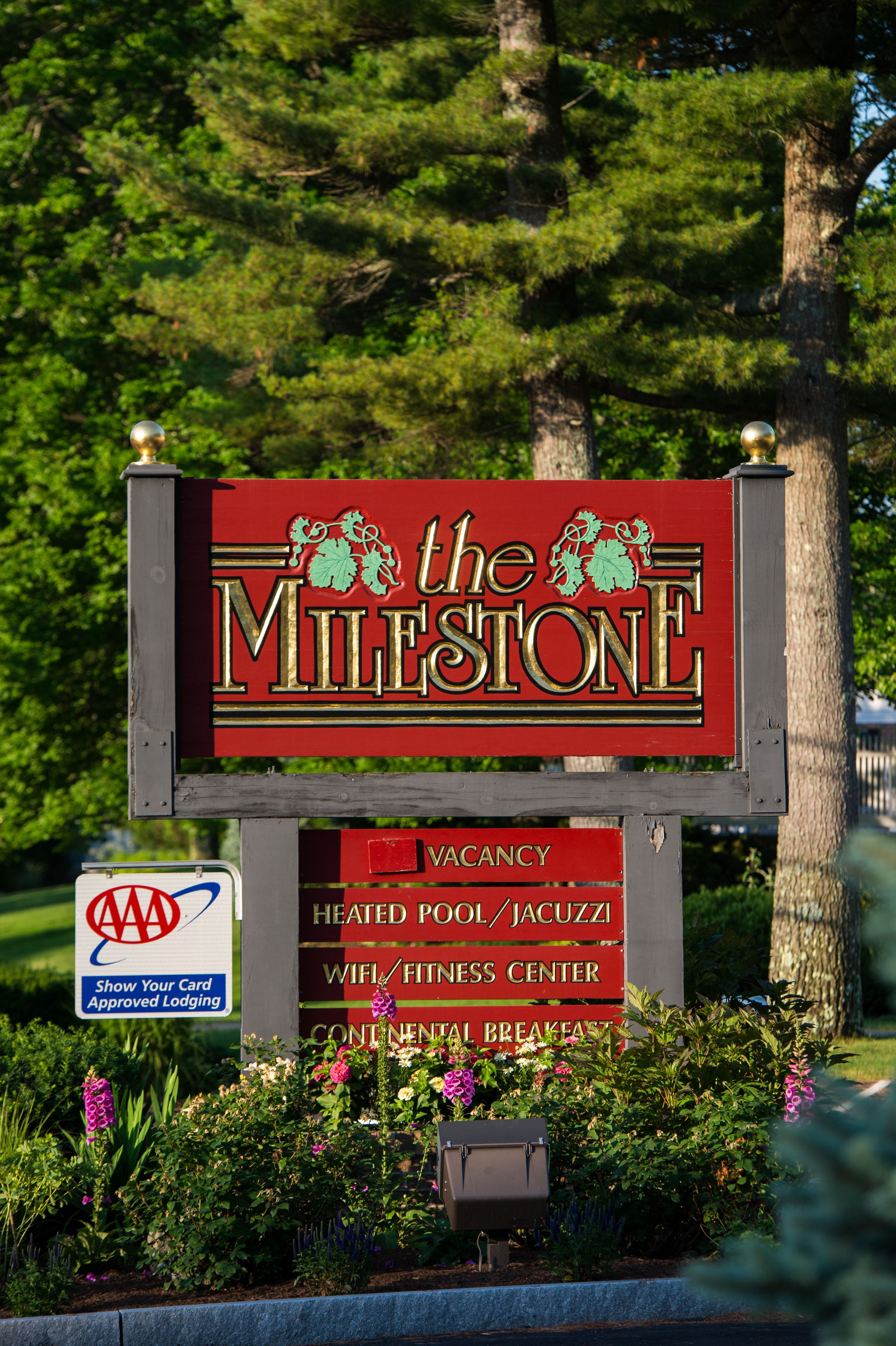 Naamplaatje voor 'The Milestone' met faciliteiten zoals een verwarmd zwembad, jacuzzi, WiFi, fitnessruimte en continentaal ontbijt.