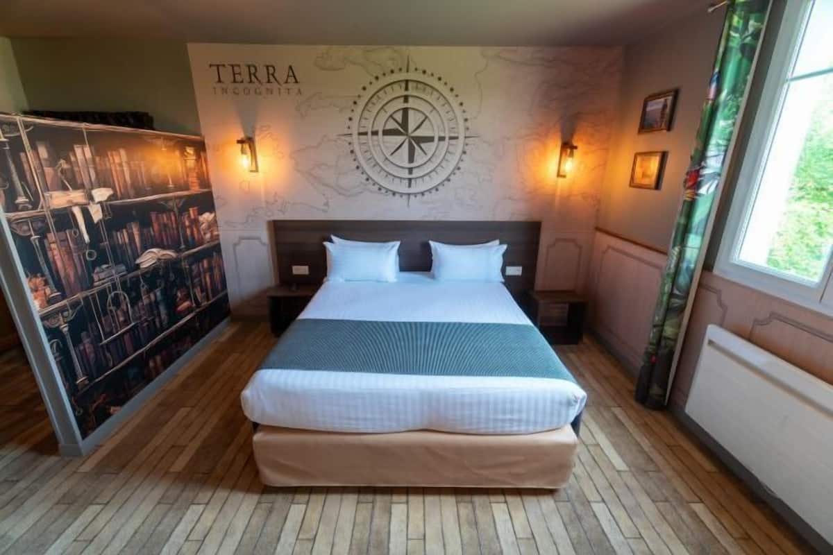 A neatly arranged bedroom with a large bed, a wall map, and a bookshelf.