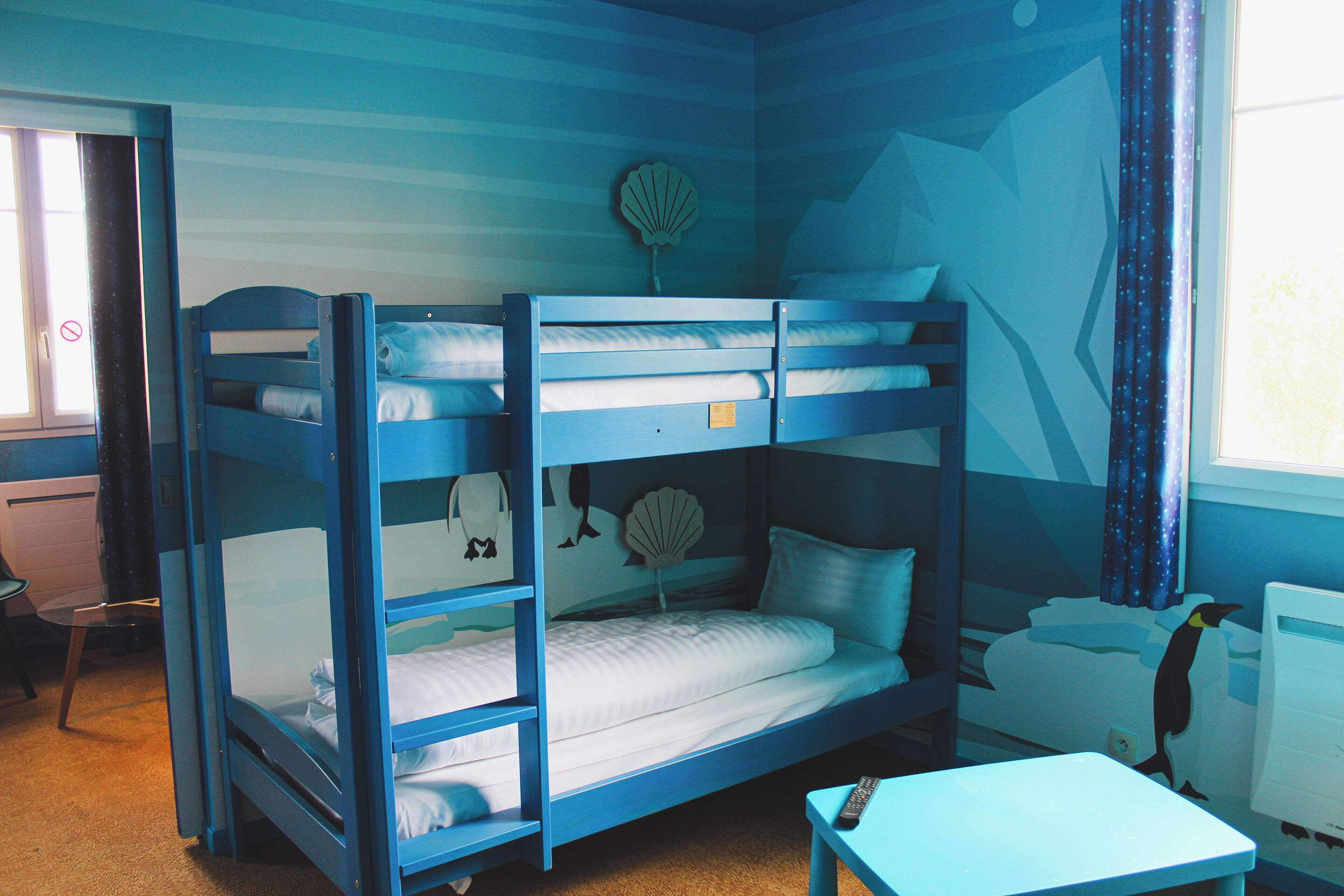 Une chambre avec un lit superposé, un bureau et une chaise.
