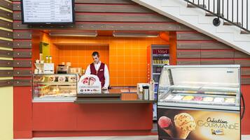 Una tienda de postres con una pizarra de menú, un mostrador y una vitrina de helados.