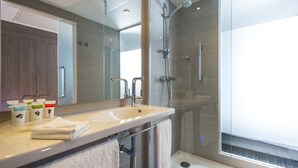 A modern bathroom with a large sink, mirror, and glass shower enclosure. - Holiday Inn London - West by IHG (London)