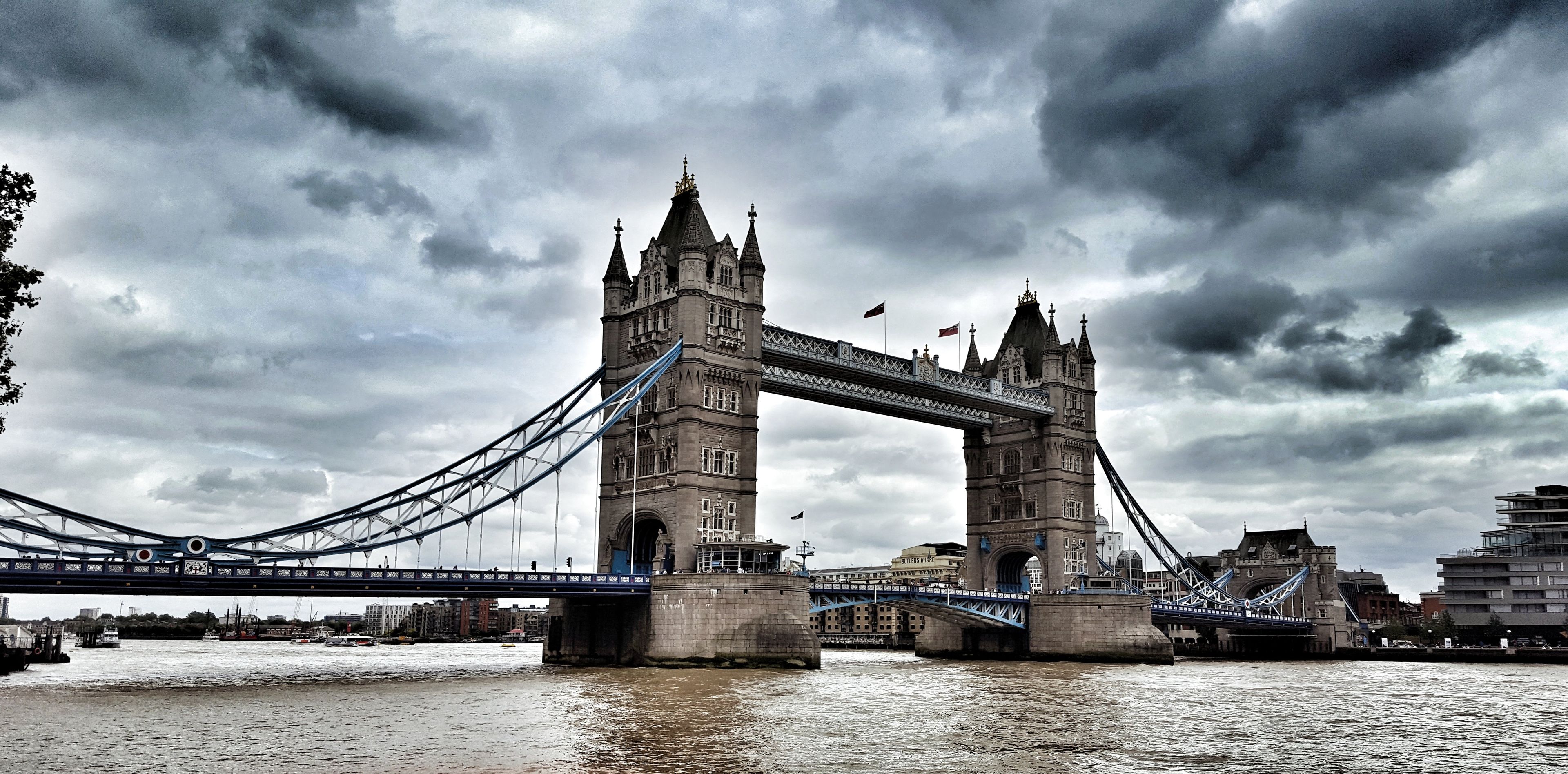 A large stone bridge with two towers and a suspension section, spanning a body of water.
