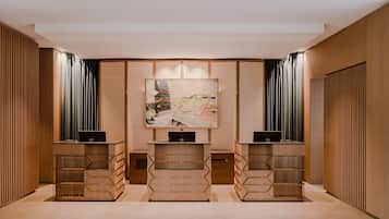 A modern hotel lobby with three reception desks, a large abstract painting on the wall, and wooden paneling on the walls.