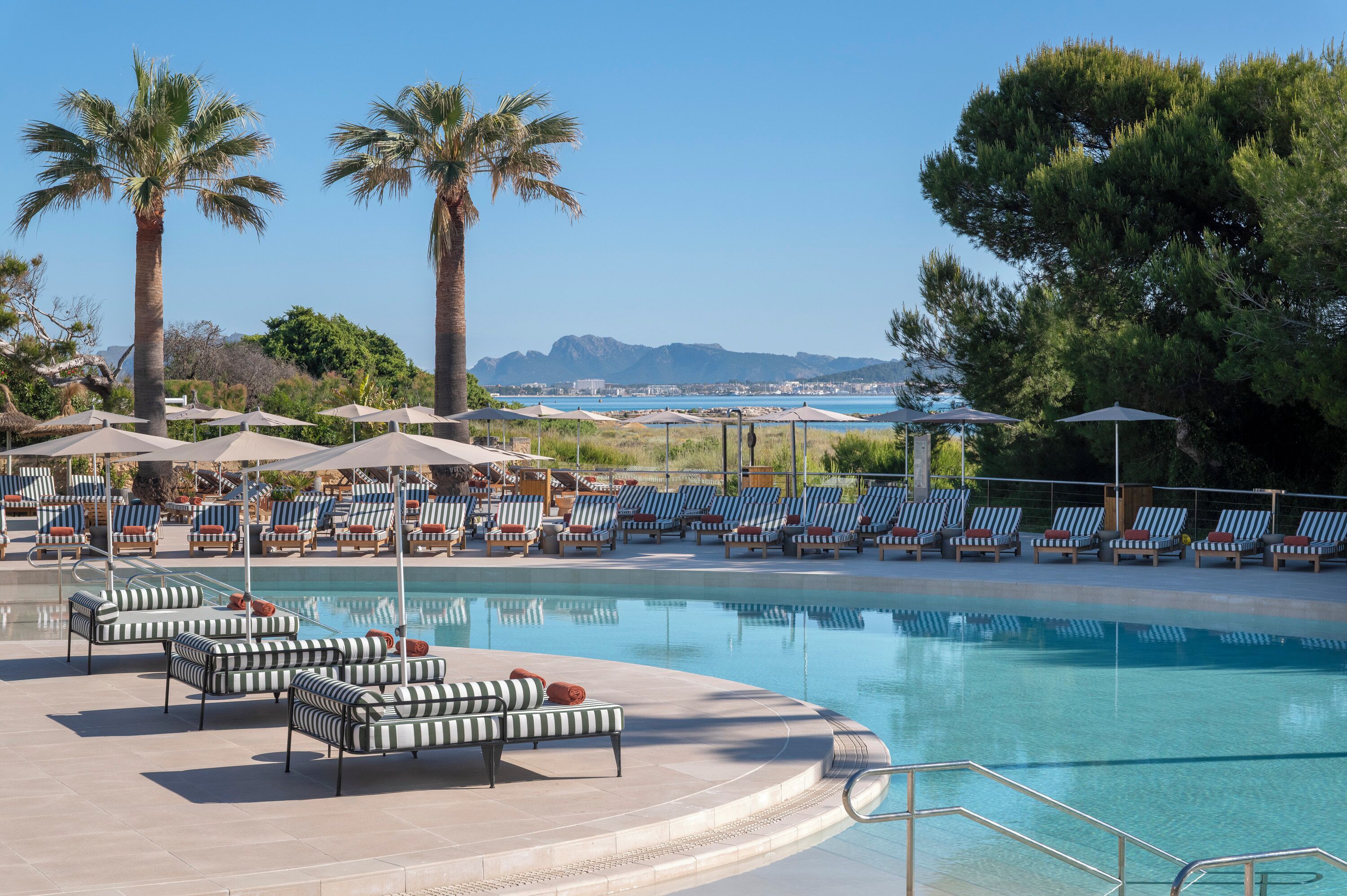 Una piscina techada, una piscina al aire libre, sombrillas
