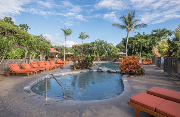 A pool area with lounge chairs and a small waterfall feature.