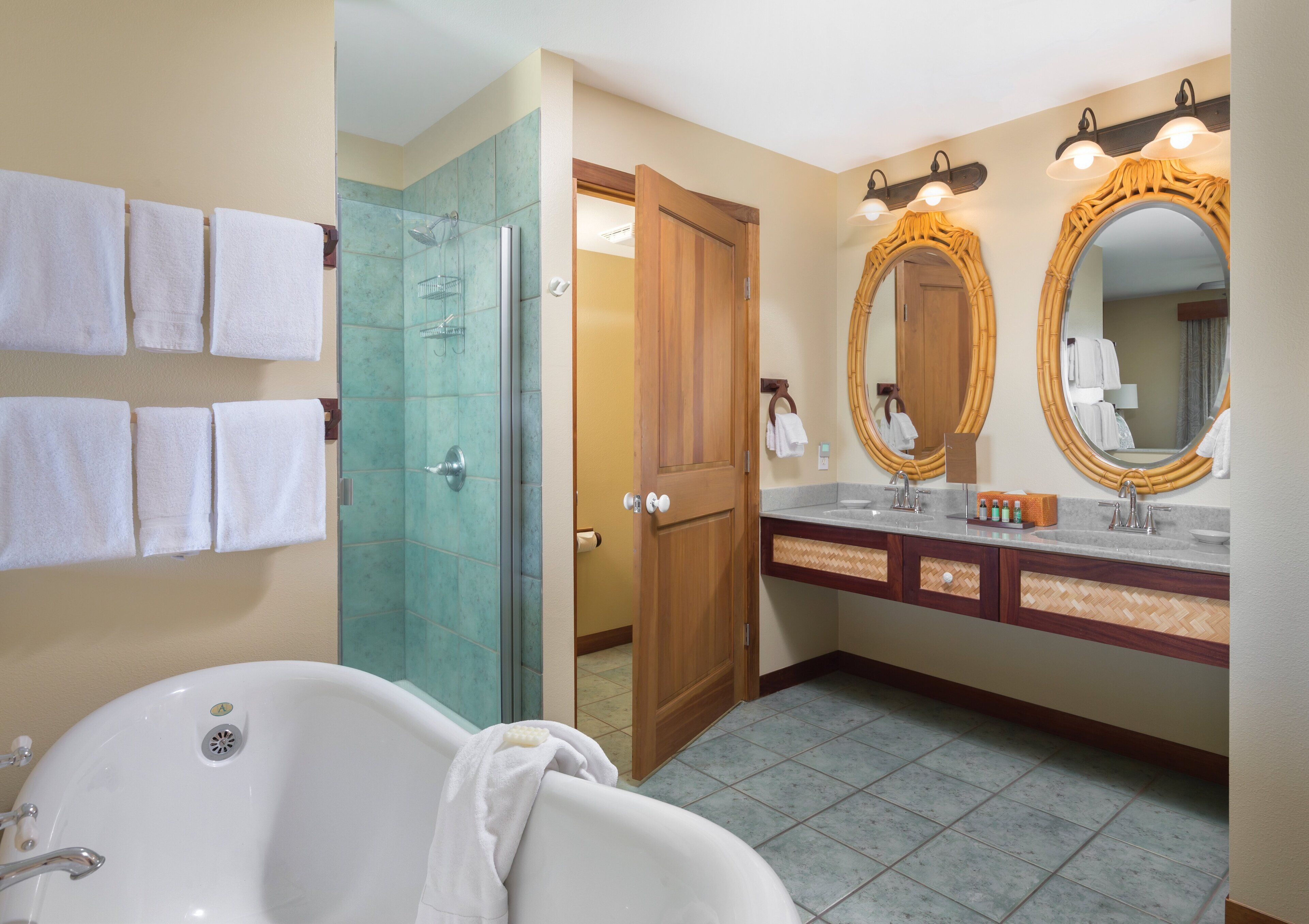 Een badkamer met een bad, een douche en een wastafel met spiegel.