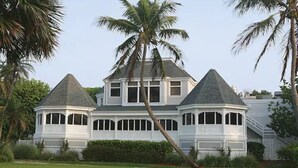A large, two-story house with a wrap-around porch and a steeply pitched roof. - Casa Ybel Resort (Sanibel)