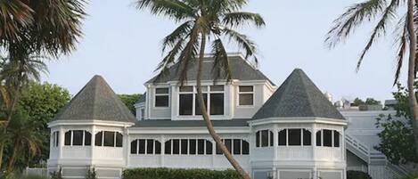 A large, two-story house with a wrap-around porch and a steeply pitched roof.