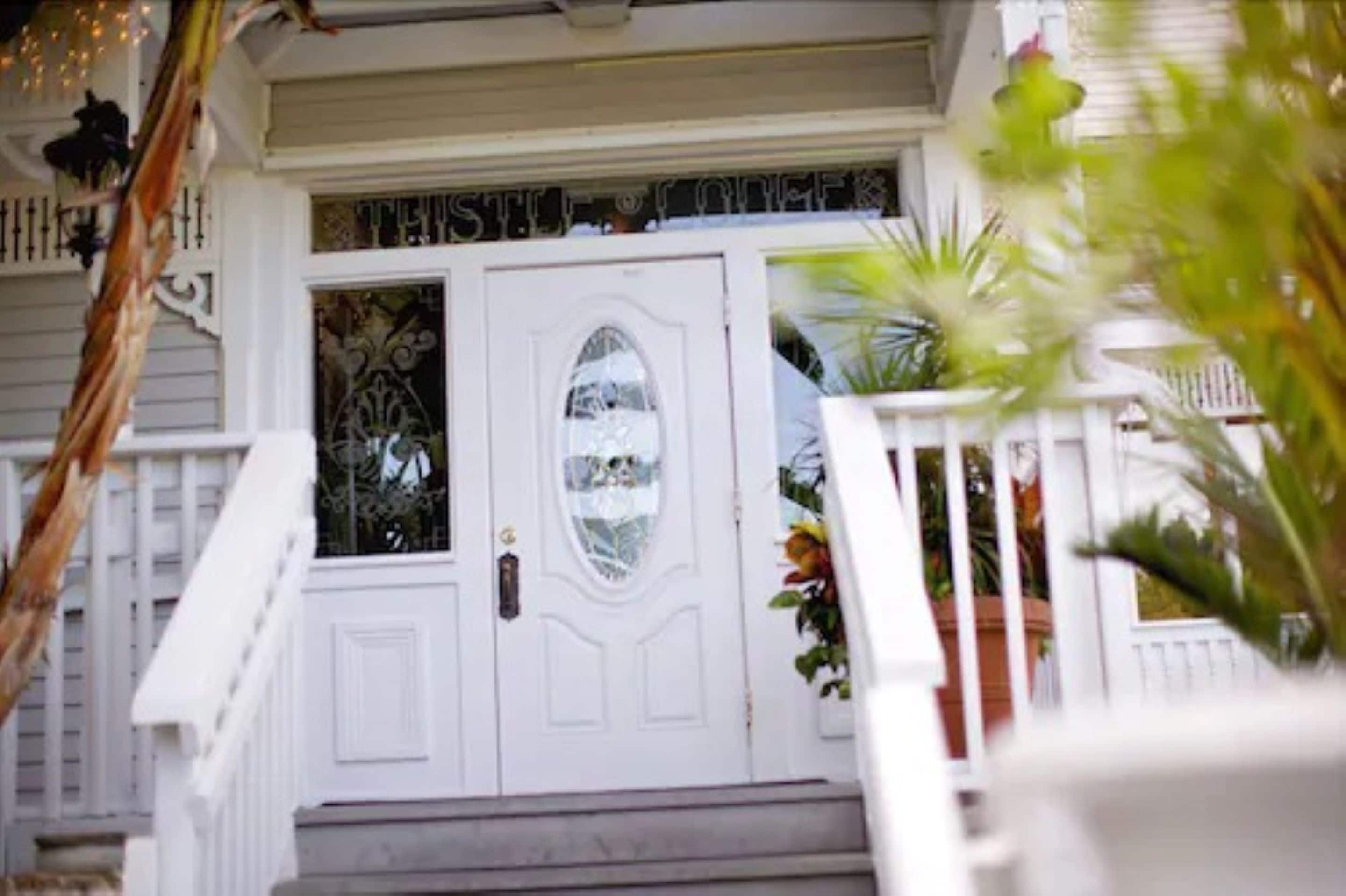 A white front door with a glass panel and a small balcony with a railing.