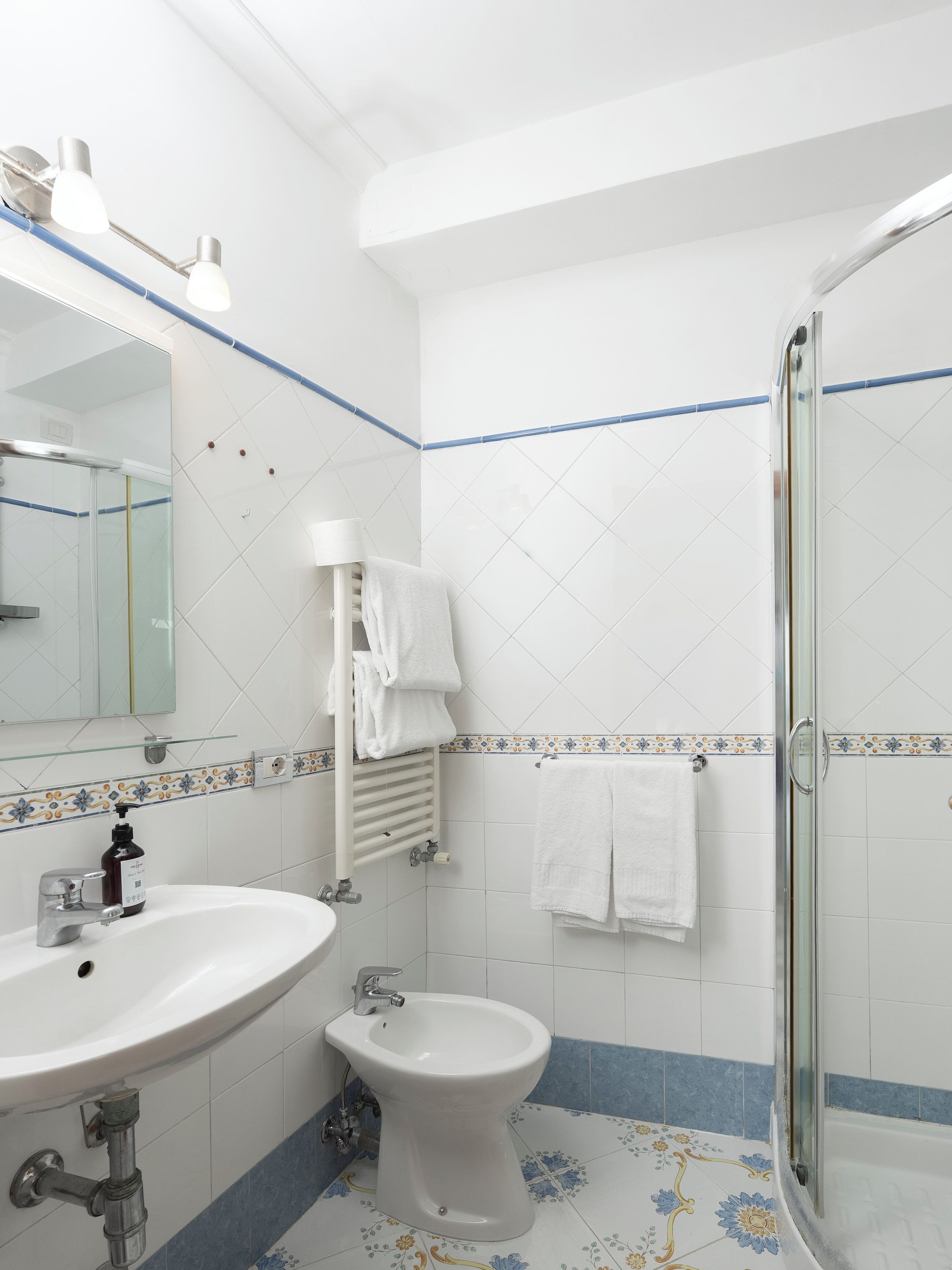 A bathroom with a sink, bidet, and shower.