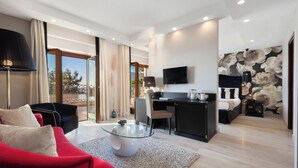 A modern living room with a glass coffee table, a red sofa, and a black desk with a flat-screen TV.