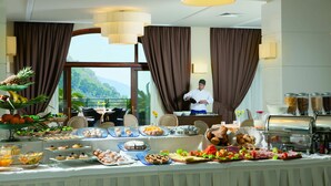 A buffet setup with various food items and a chef preparing food.