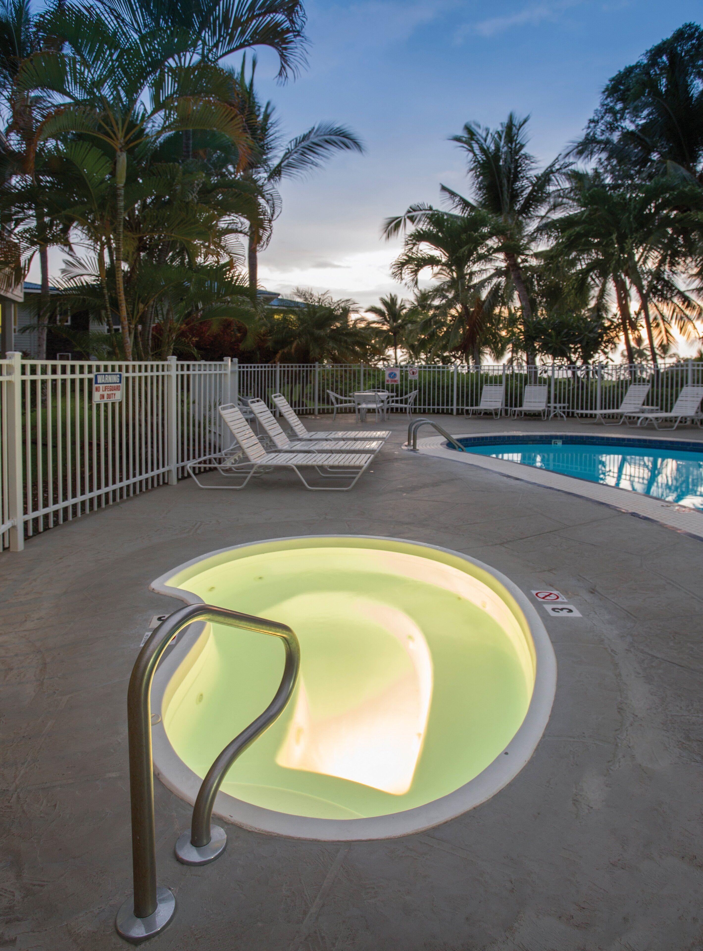 A pool area with lounge chairs and a pool.