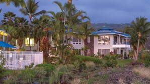 Una propiedad frente al mar con una casa, una piscina y una cascada.