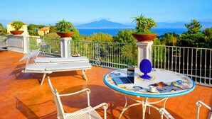 A terrace with outdoor seating, a laptop, and potted plants. - Atlantic Palace Hotel (Sorrento)