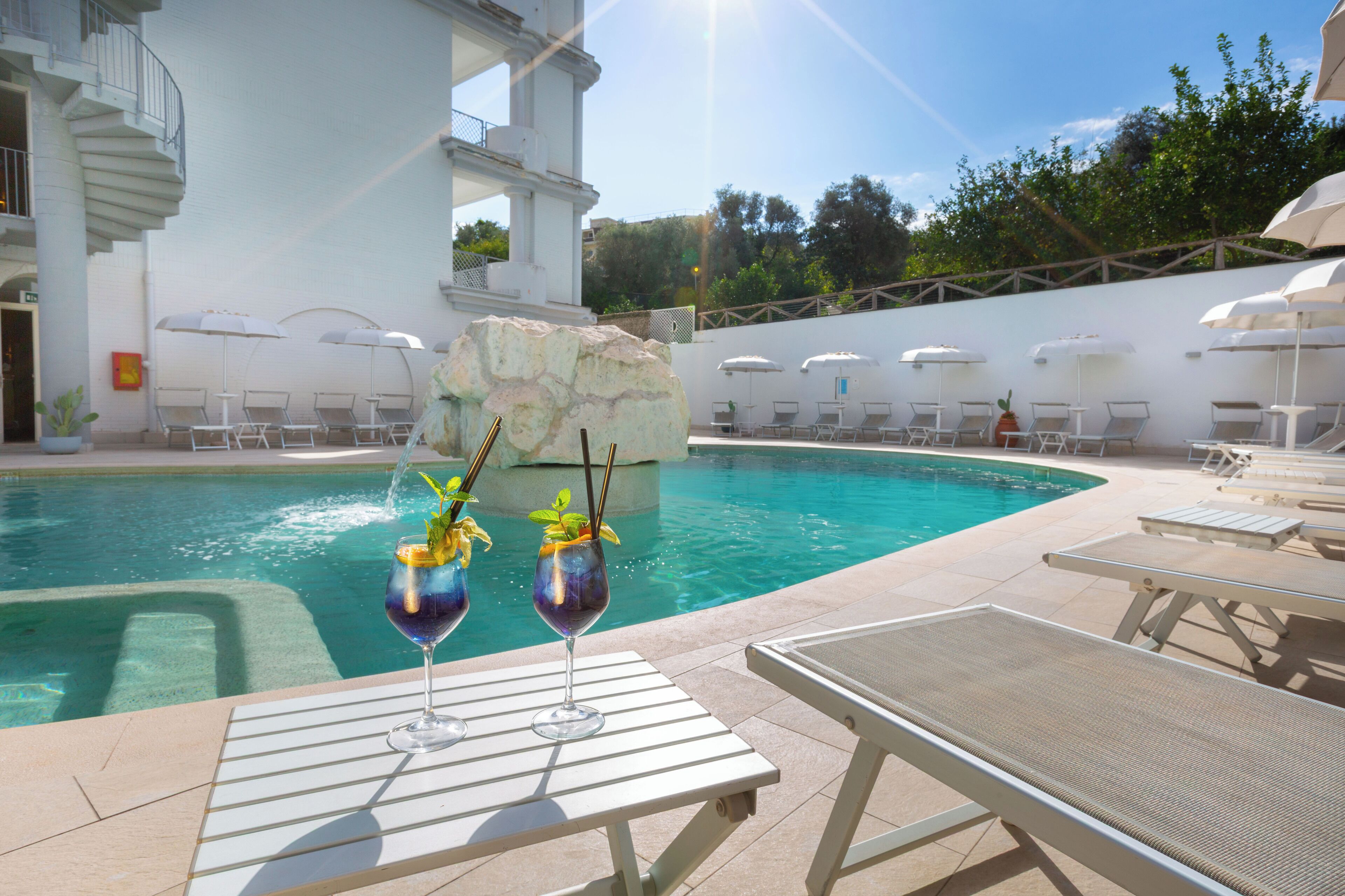 Una piscina al aire libre de temporada, sombrillas