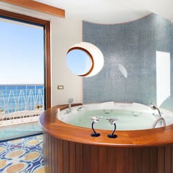 Suite junior, hidromasaje, vista al mar | 1 habitación, minibar, caja de seguridad en la habitación y escritorio